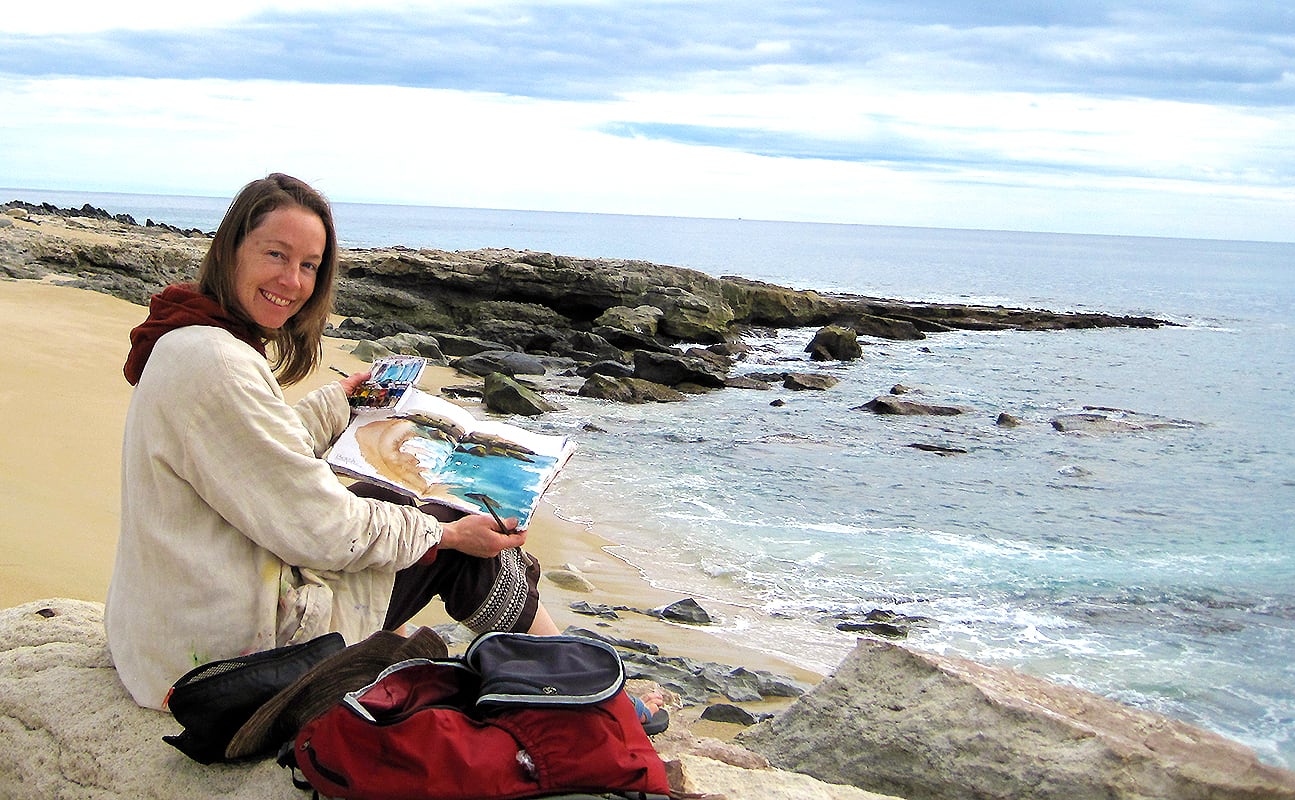 kellie day painting in her art journal on the beach in mexico